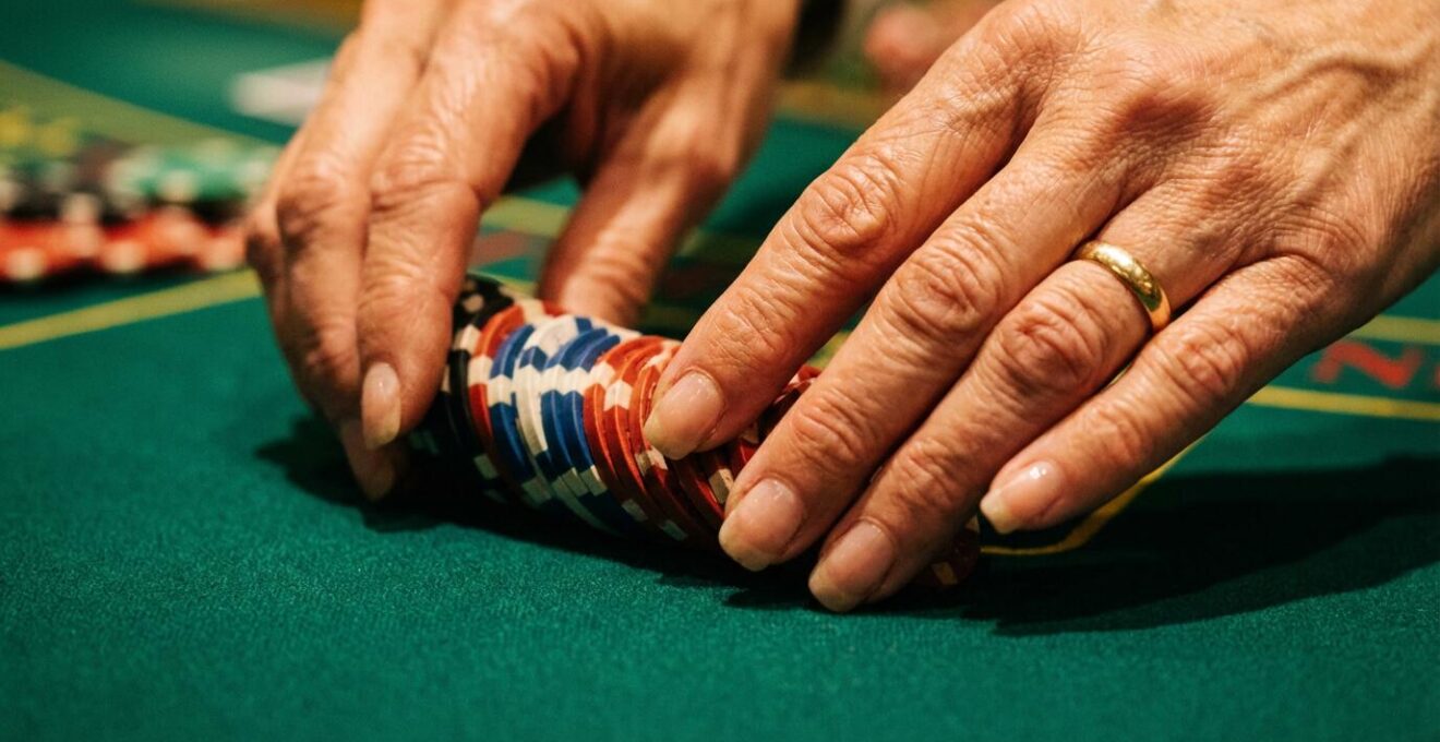 Gros plan sur les mains expertes d'un croupier manipulant des jetons colorés sur le tapis vert d'une roulette française